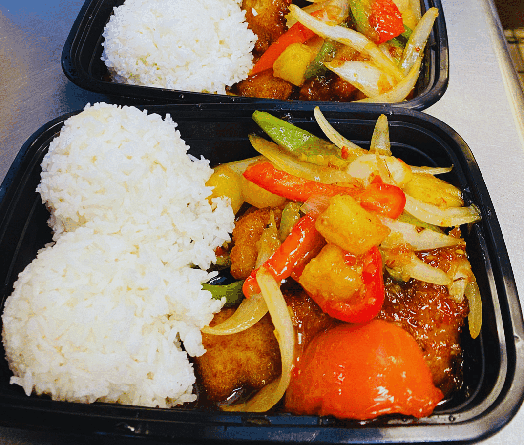 Two black containers with rice, chicken, and colorful stir-fried vegetables.